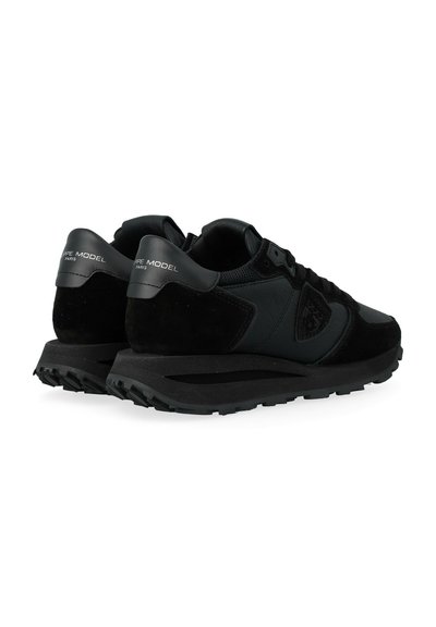 Le scarpe da ginnastica nere presentano un mix di materiali in suede e mesh, un design elegante, una suola in gomma testurizzata e un logo discreto sul tallone.