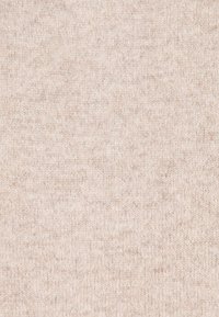 Weiches, beiges Strickmaterial mit feiner, gleichmäßiger Textur und subtilen Schattierungsvariationen.