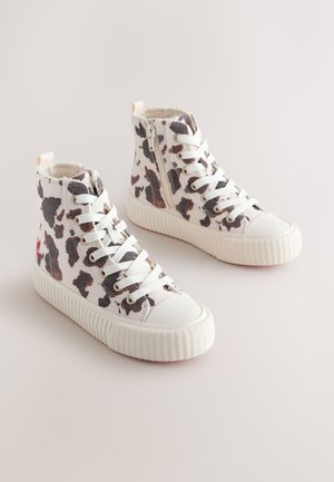Höga sneakers i vitt tyg med svart och brunt kohudsmönster, gummität tåhätta och texturerad vit sula med snören.