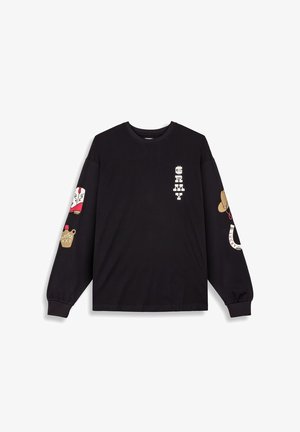 Camisa negra de manga larga hecha de algodón. Presenta gráficos en las mangas, incluyendo un zapato, una taza marrón y texto estilizado en el pecho.