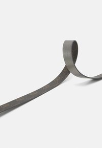 Nastro grigio con una texture liscia, caratterizzato da un motivo a logo ripetuto in una tonalità più scura, arrotolato con un'estremità in posizione verticale.