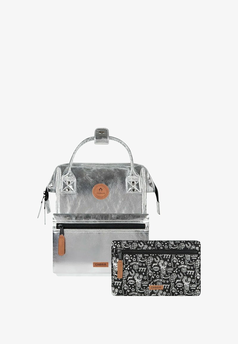 Silver metallic backpack with a textured finish, featuring a round logo patch and a detachable black zippered pouch with white patterns.