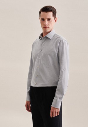 Hellblaues, knöpfbares Hemd mit Mikro-Muster, langen Ärmeln, Kentkragen und Brusttasche, aus glattem, gewebtem Stoff.