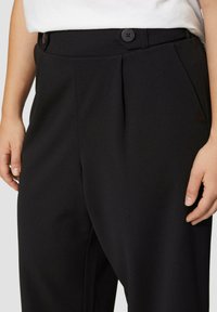 Zwarte broek met een getailleerde pasvorm, met twee voorplooien, een gladde textuur en twee knopen bij de tailleband voor sluiting.