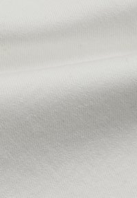 Tessuto di cotone bianco con una superficie morbida e strutturata e un delicato motivo a coste, che presenta sottili variazioni di tonalità e tessitura.