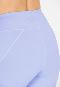 Ljuslila högmidjade leggings tillverkade av ett smidigt, stretchigt material. Har subtila texturerade linjer och förstärkta sömmar för hållbarhet.