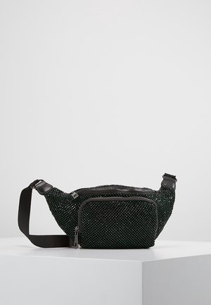 Zwarte taille-tas met kralen, voorzien van een voorzak met ritssluiting en een verstelbare zwarte stoffen riem, tentoongesteld op een wit voetstuk.