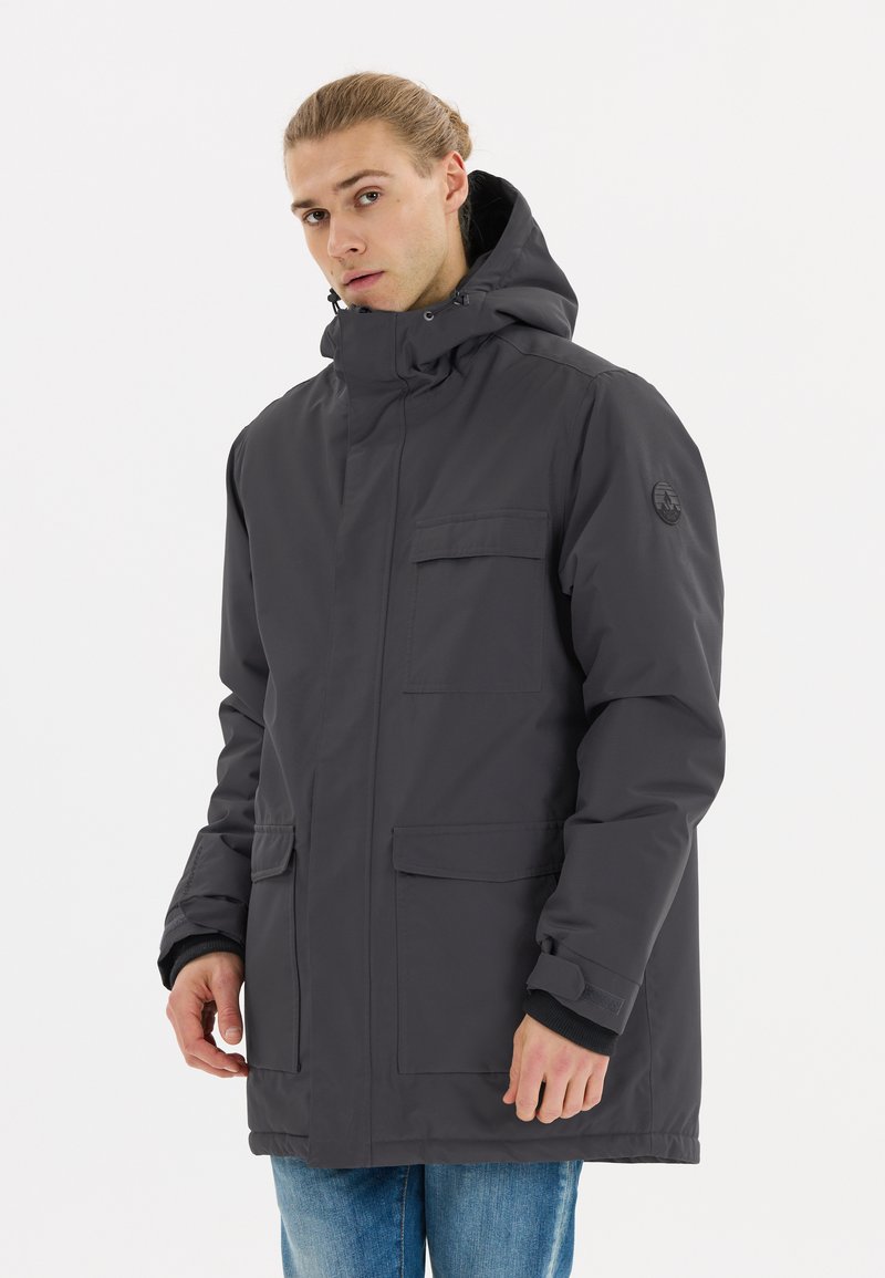 Mörkgrå vattentät parka med hög krage, justerbar huva, framfickor och elastiska ärmar. Har en logotyp på vänster ärm.