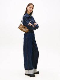 Ensemble composé d'une chemise en denim et d'un jean à jambes larges, bleu foncé avec des poignets gris contrastants, associé à un sac à main en imprimé léopard et des mocassins noirs.