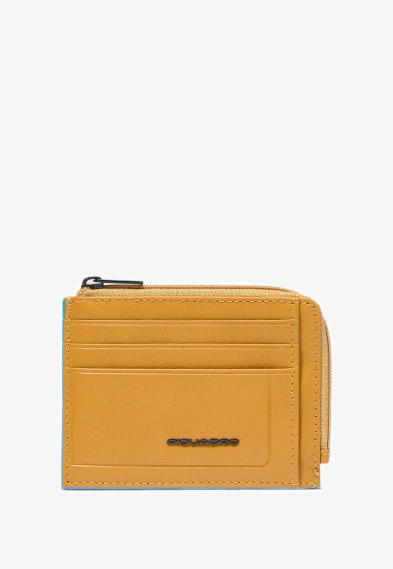 Portatarjetas de cuero color canela con cuatro ranuras para tarjetas, un bolsillo con cremallera para monedas y un pequeño logo de la marca en negro en el frente.