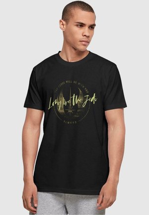 Black cotton T-shirt featuring a gold graphic print that includes the text "Long Live the Jedi" and a circular emblem design.