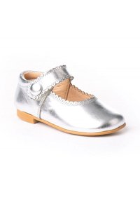 Zapato Mary Jane metálico plateado con borde festoneado, tira ajustable, puntera redonda y suela de goma marrón. Adecuado para niños.