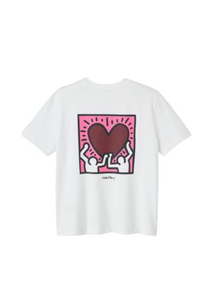 T-shirt en coton blanc avec un design graphique au dos : deux figures stylisées soulevant un cœur marron sur un fond rose.