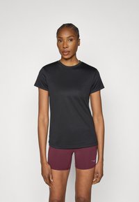 Fekete sportos póló kerek nyakkal, rövid ujjú és sima tapintású, bordó rövidnadrággal párosítva, amelyen kis logó látható.