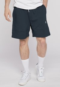 Men's navy blue shorts made of soft fabric, featuring an elastic waistband, side pockets, and a small white logo detail.
