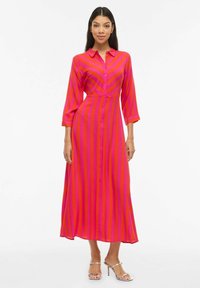 Robe à boutons aux rayures rose vif et fuchsia, avec un col et des manches trois-quarts, tissu fluide, longueur mi-mollet.