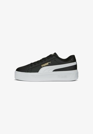 Black leather sneaker with white accents and a textured white platform sole. Features gold logo and lace-up design.