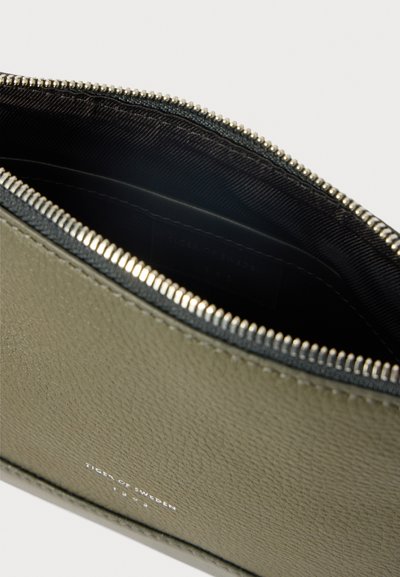 Pasta de pele verde-azeitona aberta com fecho de metal prateado e interior em tecido preto, exibindo o texto da marca "Tiger of Sweden 1903" na parte da frente.