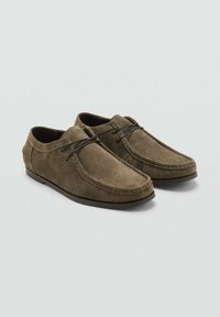 Dark olive green suede shoes with a rounded toe, subtle stitching details, and a lacing accent at the front. Flat rubber sole.