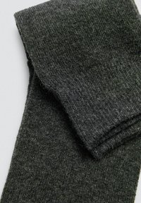 Calcetines de lana gris oscuro, con una textura acanalada, un puño doblado y un acabado suave. El material parece suave y cálido.