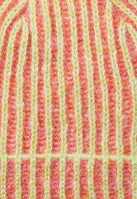 Cappello lavorato a maglia con strisce alternate di rosa soffice e verde chiaro. Le fibre texturizzate creano un motivo a coste in rilievo.
