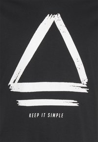 Svart t-shirt med en stor vit målade triangulär grafik och texten "HÅLL DET ENKELT" nedanför i ett rent, modernt typsnitt.