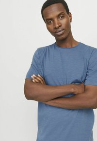 Short-sleeve blue t-shirt made of soft fabric, featuring a round neckline and a relaxed fit. Texture appears smooth with a slight sheen.