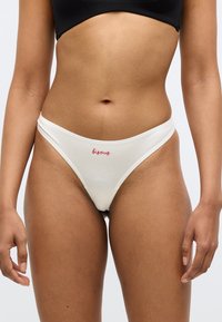 Tanga albă din bumbac, cu talie joasă și accent text „bisous” roșu. Textură moale cu un finisaj neted. Proiectată pentru confort și potrivire.