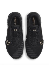 Scarpe sportive nere realizzate in materiale a rete, con una parte superiore strutturata, lacci piatti e dettagli dorati sul logo e sulle rifiniture.