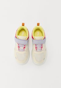 Skrienēšanas apavi ar bēšas krāsas acu auduma augšdaļu, purpura siksnu, rozā akcentiem un zaļo apdari. Iekļautas auklas un vilkšanas cilpa vieglai uzvilkšanai.