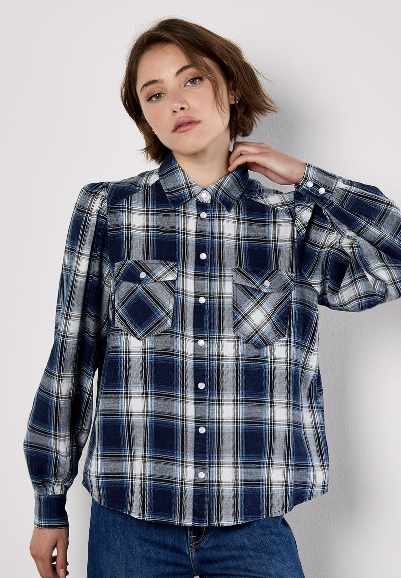 Blue and white plaid long-sleeve shirt with button front, two chest pockets, and shoulder detailing. Cotton fabric, relaxed fit.