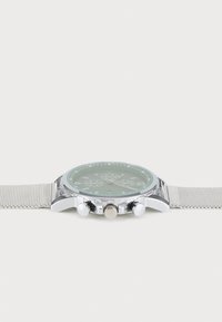 Silberne Mesh-Armbanduhr mit rundem grünen Zifferblatt, drei Chronographen-Subdials und polierten silbernen Beschlägen. Weiße Krone und Drücker inklusive.