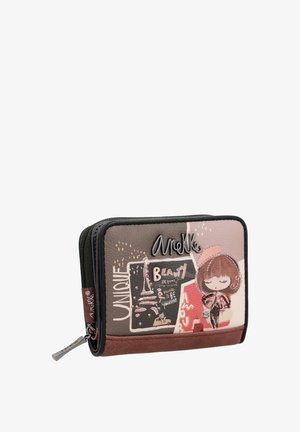 Cartera hecha de cuero texturizado con cierre de cremallera. Presenta un diseño impreso con elementos parisinos, un personaje de dibujos animados y acentos metálicos.