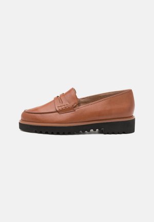 Mocassino in pelle marrone con un dettaglio intrecciato sul davanti, punta tonda e una suola in gomma nera spessa con grip testurizzato.