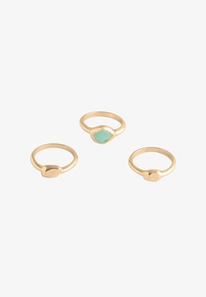 Three gold rings displayed together, each with a smooth band and a unique, shaped stone accent in light blue.