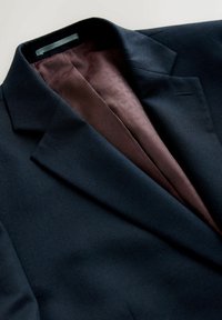 Marineblauer Blazer mit strukturierter Außenseite und einem weinroten, gemusterten Futter. Verfügt über einen Reverskragen mit Kerbe und eine einzelne Brusttasche.