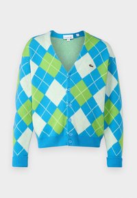 Cárdigan abotonado con un patrón de argyle en azul, verde y blanco, puños y dobladillo acanalados, y un pequeño logo de cocodrilo en el pecho.