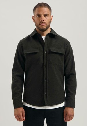 Donkergroene flanellen shirt met een kraag, knoopsluiting aan de voorkant, twee borstzakken en lange mouwen. Het shirt heeft een gestructureerde stof en een rechte zoom.