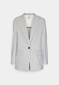 Blazer gris clair avec un col cranté, une fermeture à un bouton, deux poches avant et une texture lisse. Intérieur doublé avec des accents orange.
