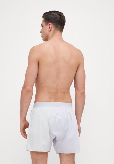 Striped cotton boxers with a soft elastic waistband, featuring a light blue and white color palette, and a loose-fit design.