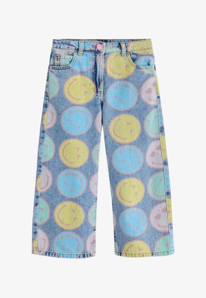 Pantaloni din denim cu picioare largi, având un model cu fețe zâmbitoare mari, în culori pastelate albastru, galben, verde și roz.