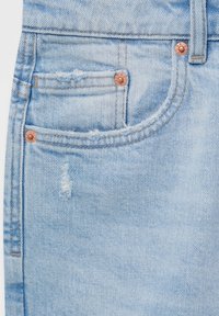 Jeans de mezclilla azul claro con un bolsillo delantero y pequeños detalles desgastados cerca de los remaches de cobre y las costuras.