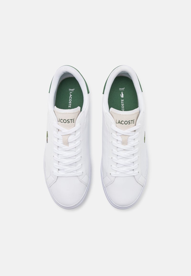 Witte tennisschoenen met een gladde leren afwerking, groene accenten op de tong en het logo, gestructureerde zolen en een klassiek vetersluiting ontwerp.