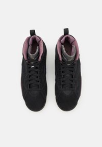 Paire de baskets montantes noires avec lacets noirs et doublure intérieure matelassée violette, vue de dessus sur fond blanc.