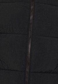 Czarna pikowana kamizelka z centralnym zamkiem błyskawicznym o teksturowanym wykończeniu, poziomym przeszyciem i lekkim materiałem zapewniającym izolację.