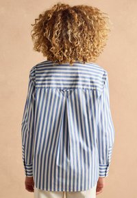 Striped long-sleeve shirt in blue and white cotton, featuring a back pleat and buttoned cuffs; relaxed fit and straight hem design.