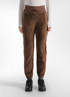 Bruine fleece joggers met een hoge taille, trekkoordsluiting, zijzakken en geribbelde boorden; gecombineerd met zwarte sneakers.