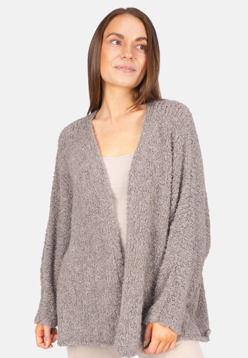 Grauer, strukturierter Cardigan mit einem lockeren, offenen Design und langen Ärmeln. Hergestellt aus weichem, flauschigem Material. Auffällig durch seinen lässigen Stil.