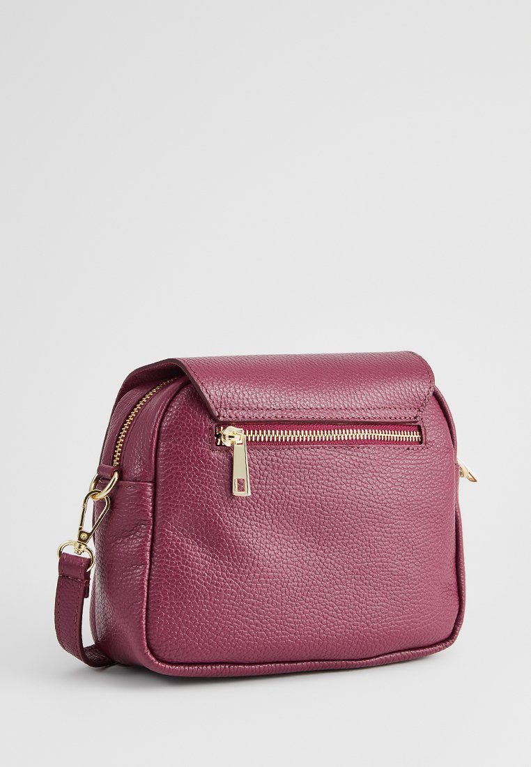 Bolso bandolera de cuero burdeos con un acabado texturizado, cierre de cremallera y herrajes en tono dorado. Cuenta con un bolsillo frontal con cremallera y correa ajustable.