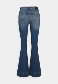 Blå denim flare jeans med en blekt finish. Har två bakfickor och en bred fåll. Tyget har en slät textur.